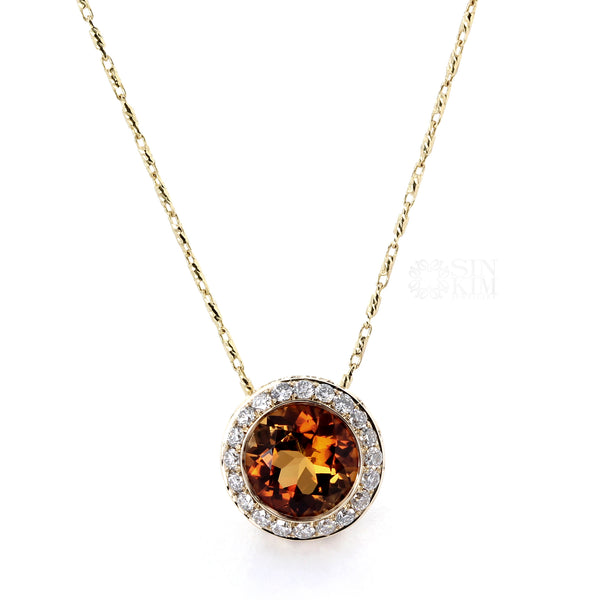 one of a kind bi coloured tourmaline set into a bezelled slider pendant with diamond halo on 14k yellow gold chain.