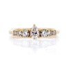 Pear  shape centre stone flanked by tapering sized round brilliant cut diamonds, set in 14k yellow gold.