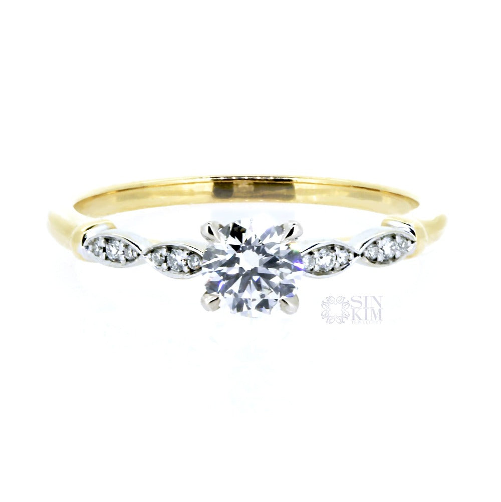 0.50ct round diamond, set in a vintage inspired, white and yellow gold,  two-toned, engagement ring.  This ring is accented with delicate, white gold, diamond pavéd petals, and four, tiger claw, centre setting.